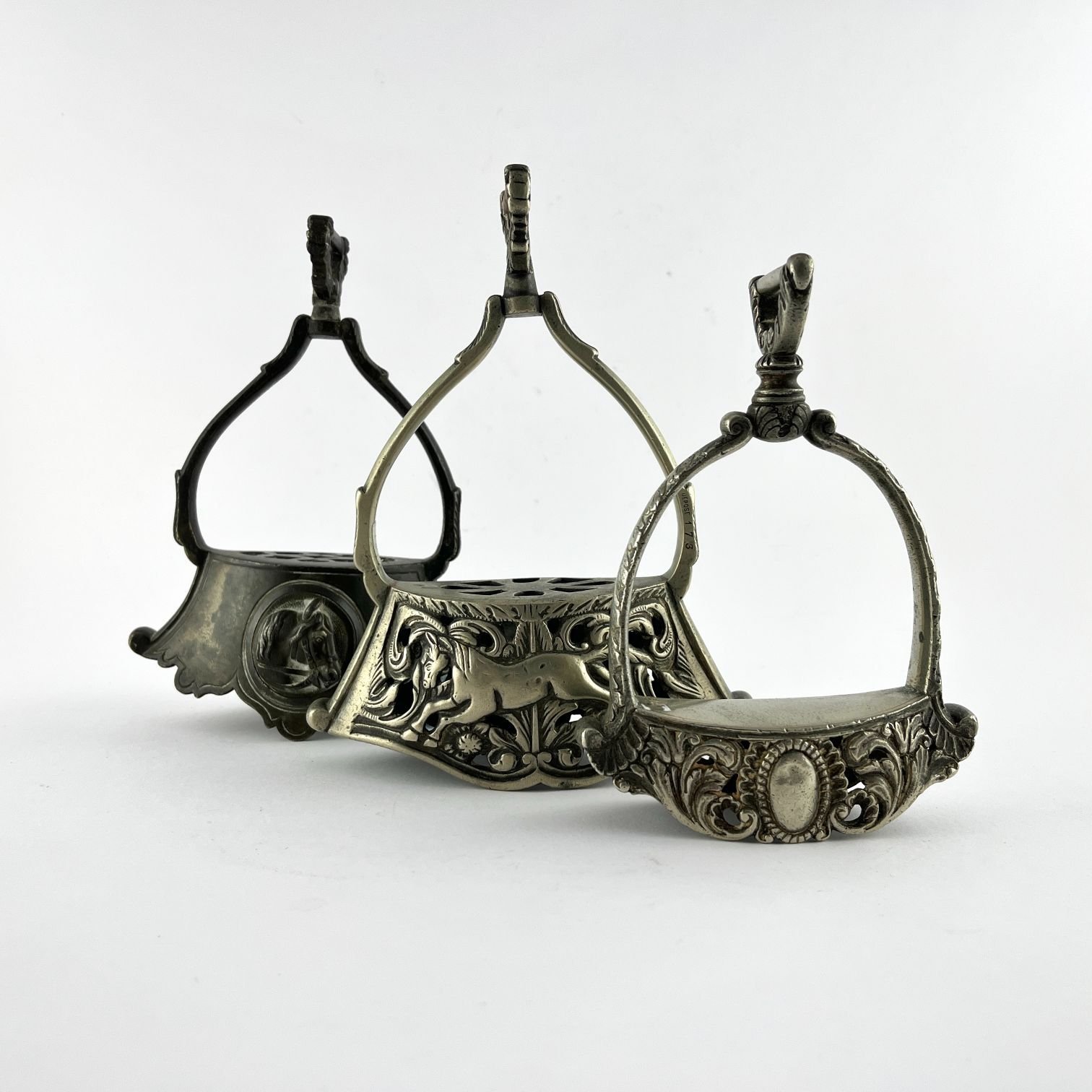 Tres estribos en metal blanco