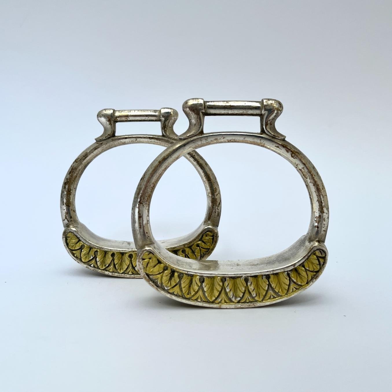 Par de estribos en metal blanco y oro