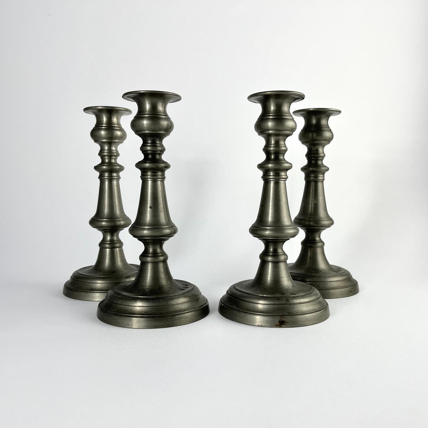 Cuatro candeleros en peltre